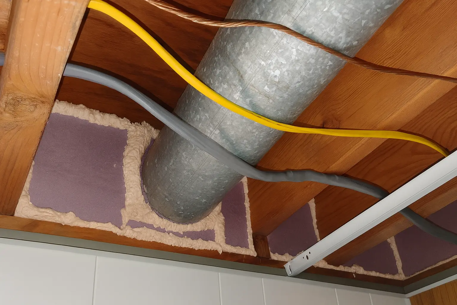 sealed duct penetration with spray foam and rigid insulation in a basement ceiling, demonstrating draft sealing work in baltimore md