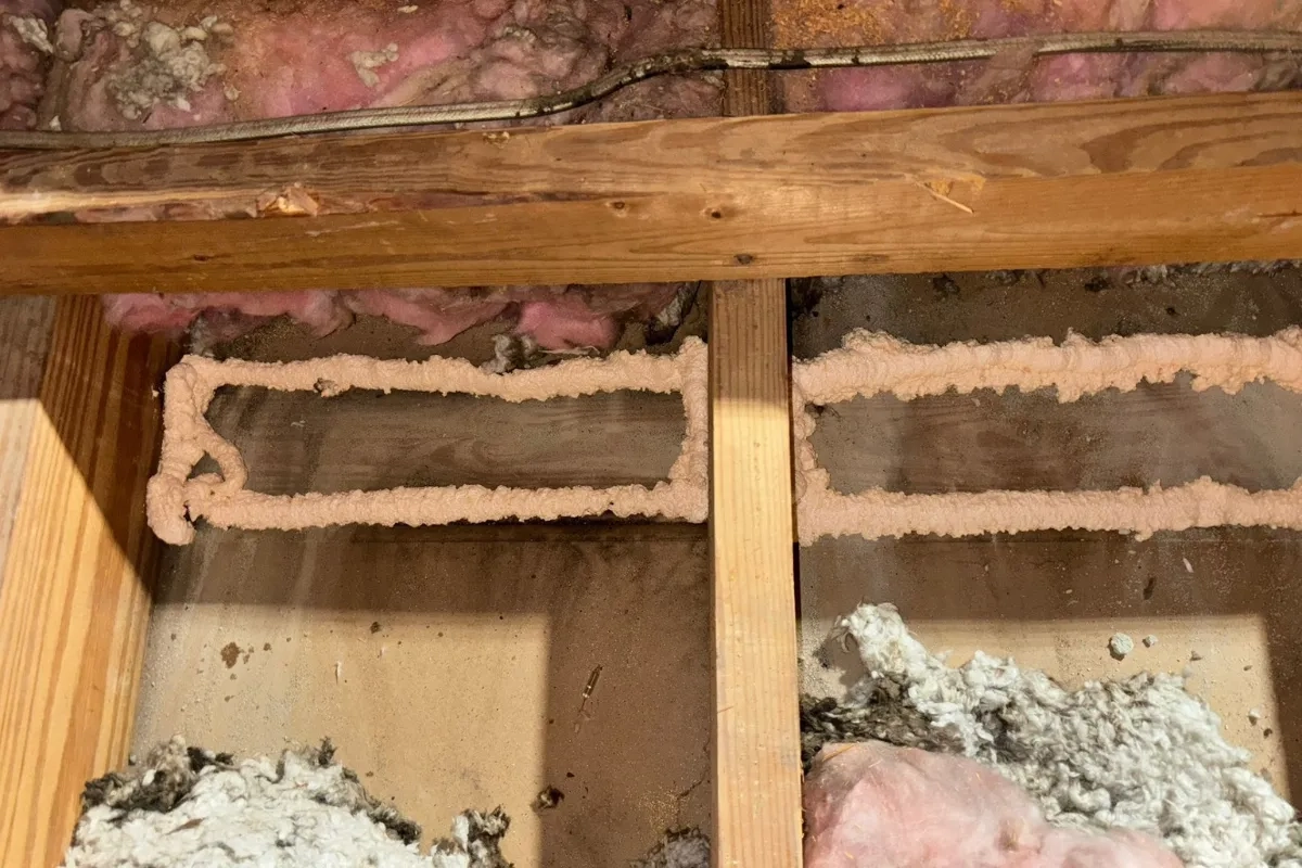 Air sealing work discovered during a home energy audit in Baltimore MD, showing gaps around joists filled with spray foam to improve insulation performance and reduce air leakage.