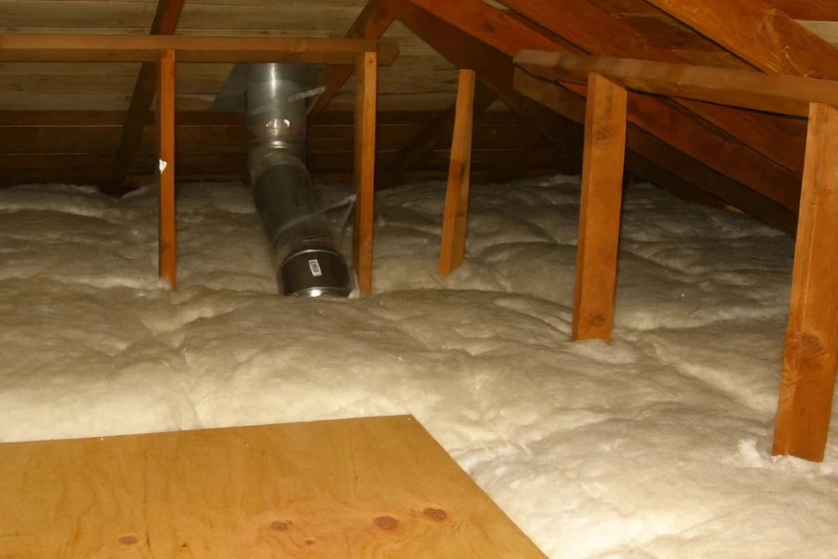 white fiberglass insulation installed in a Perry Hall attic by an insulation contractor with HVAC ductwork above